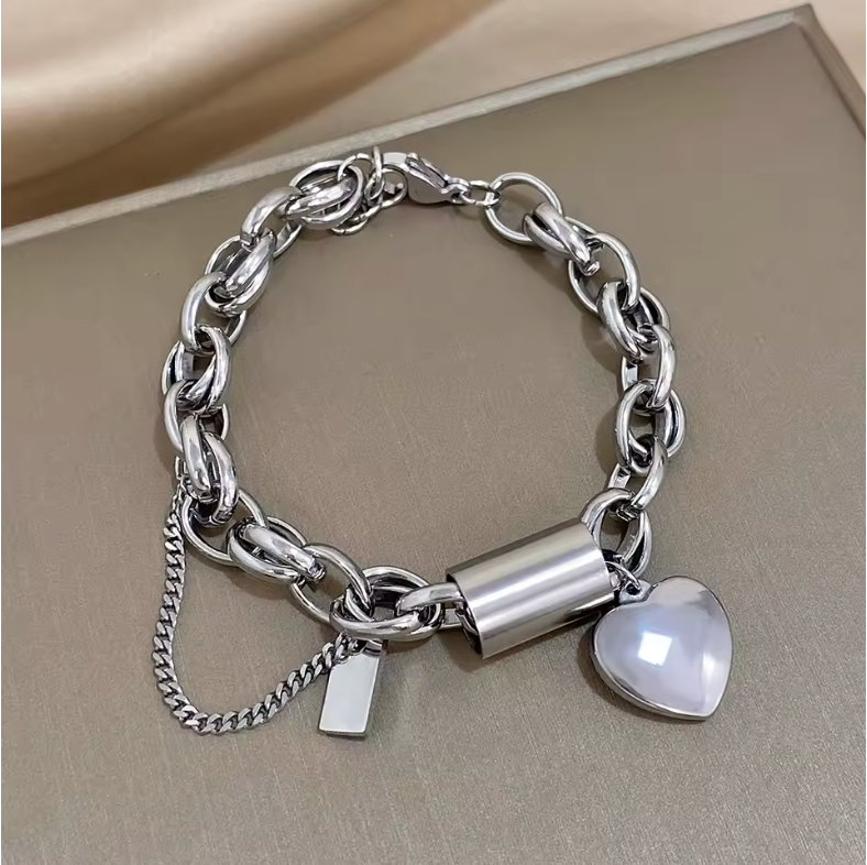 Armband mit Anhängern aus vergoldetem Metall mit einem herzförmigen Vorhängeschloss